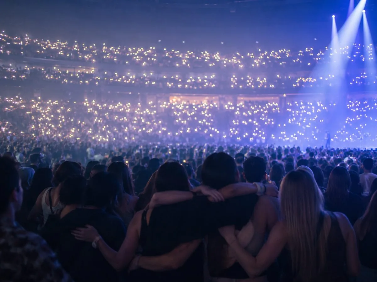 Crowd at a sold-out arena show, phones raised